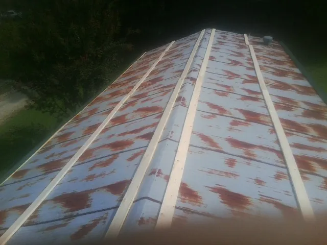 Rusted metal roof panels with new wood purlins before replacement — Storm Damage Roof Repair in Wilbraham by Roofing Brothers