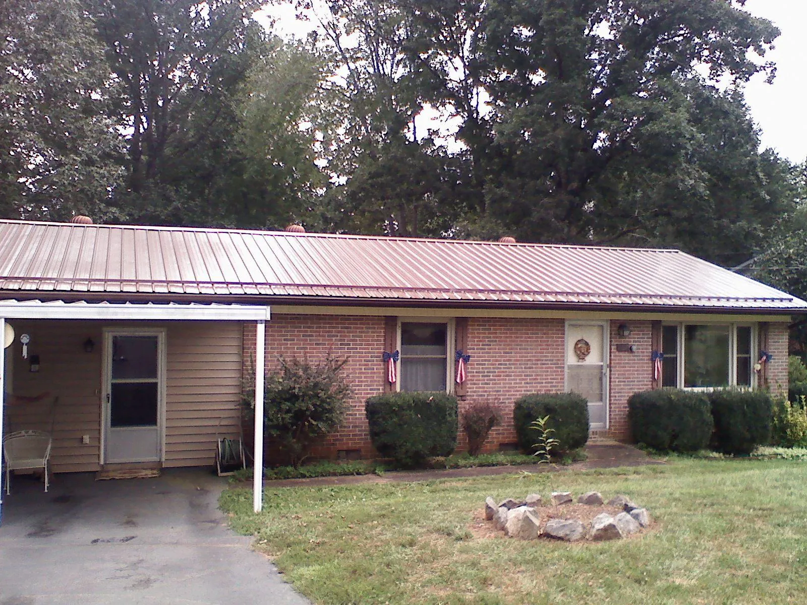 Bronze metal roof and carport on a brick ranch home — Roof Repair work by our crew in Wilbraham